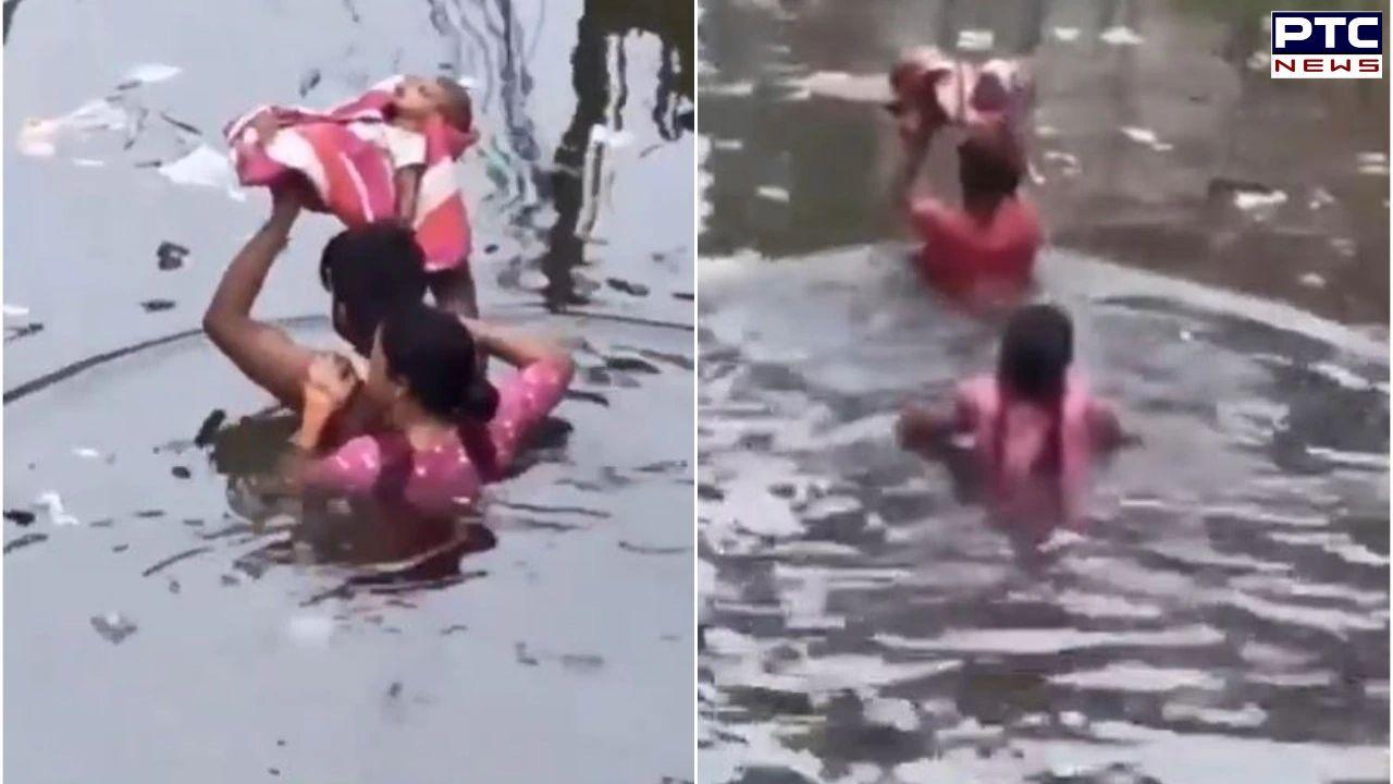 Floodwater waist-deep, parents carry infant overhead to safety in UP's Prayagraj
